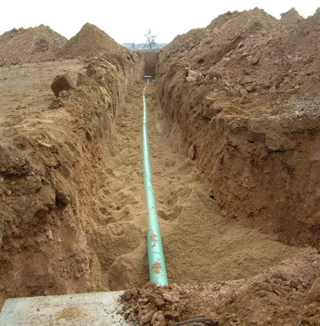 trench dividing two sides of land with a hose in the middle