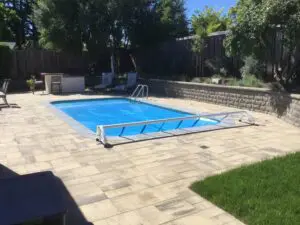 Rectangular pool with gray paver deck and block retaining wall – Marin County