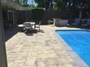 Paver patio with dining area beside pool with cover – Marin County