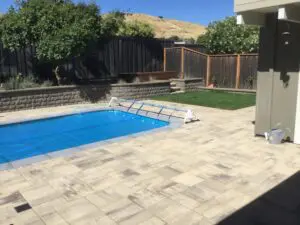 Paver pool deck with block retaining wall and lawn – Marin County