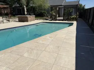 Pool with light stone paver deck along fence line – Marin County
