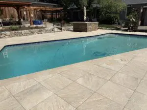 Pool with light stone paver deck and raised fire feature – Marin County
