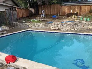 Pool with new stacked stone wall during backyard renovation – Marin County