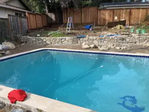Pool with stacked stone retaining wall under construction – Marin County