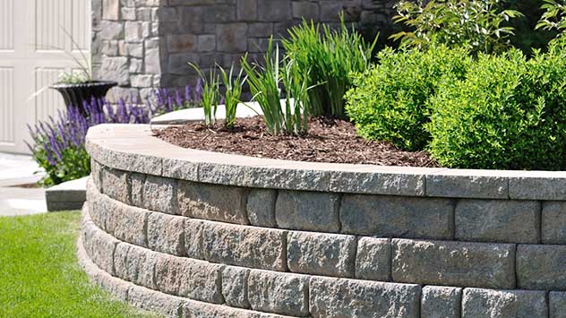 interlocking concrete blocks that create a retaining wall shaped like a semi circle